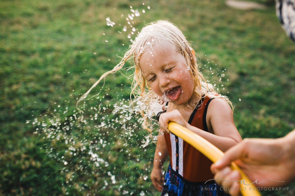 young girl drinks from the hose