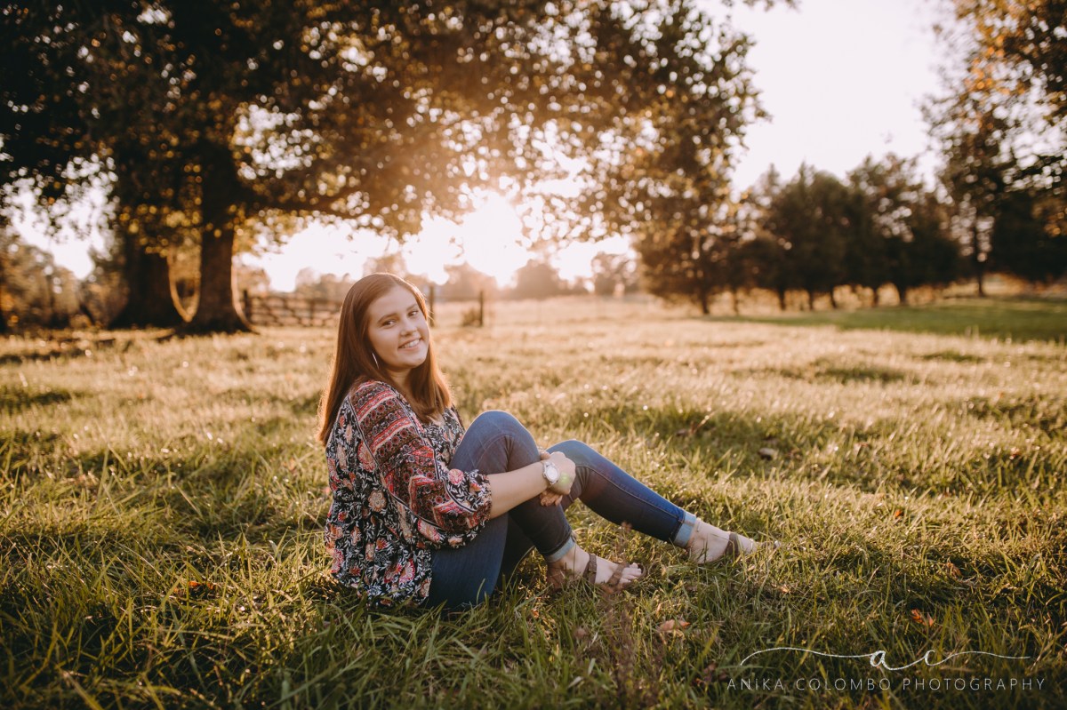 young girl in a field smiling at the camera