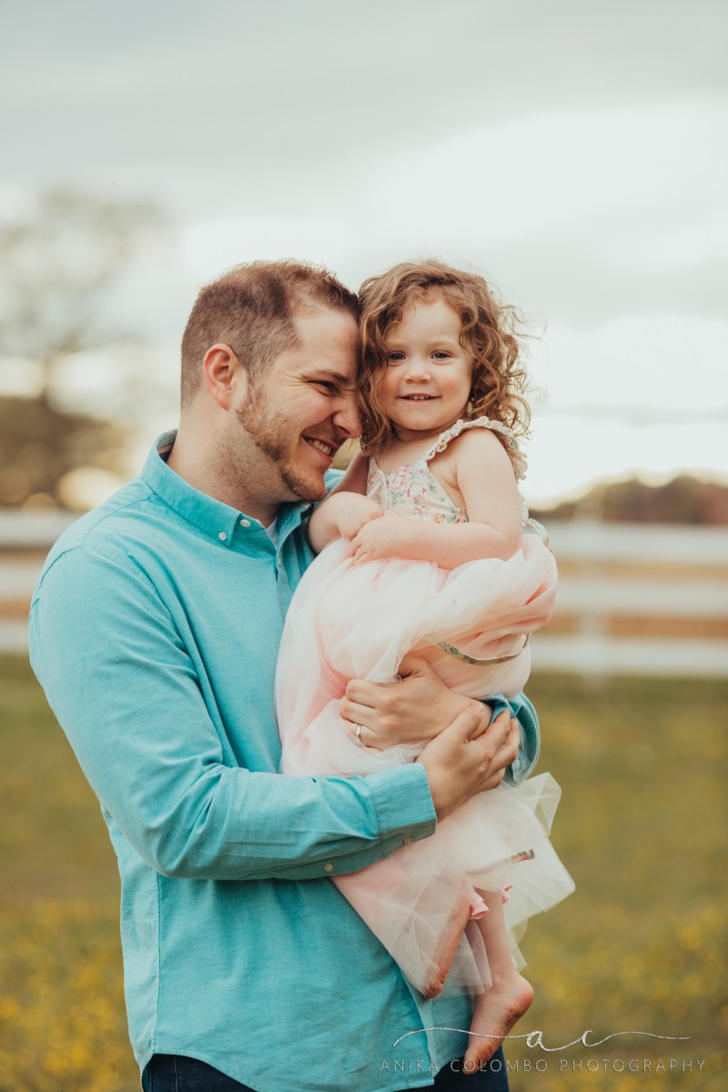 father holding his toddler daughter and nuzzling her cheek