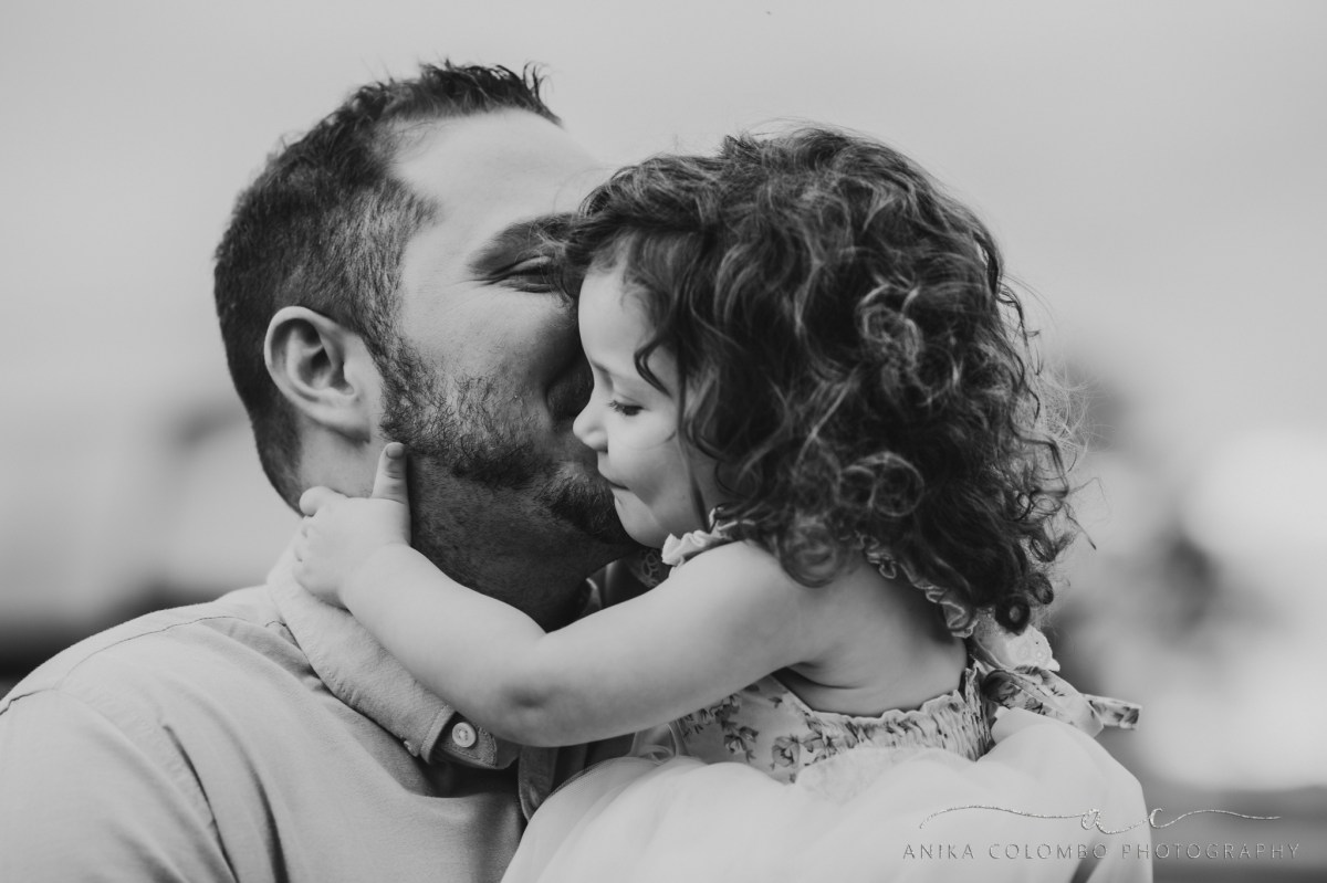 father kissing his daughter on the cheek