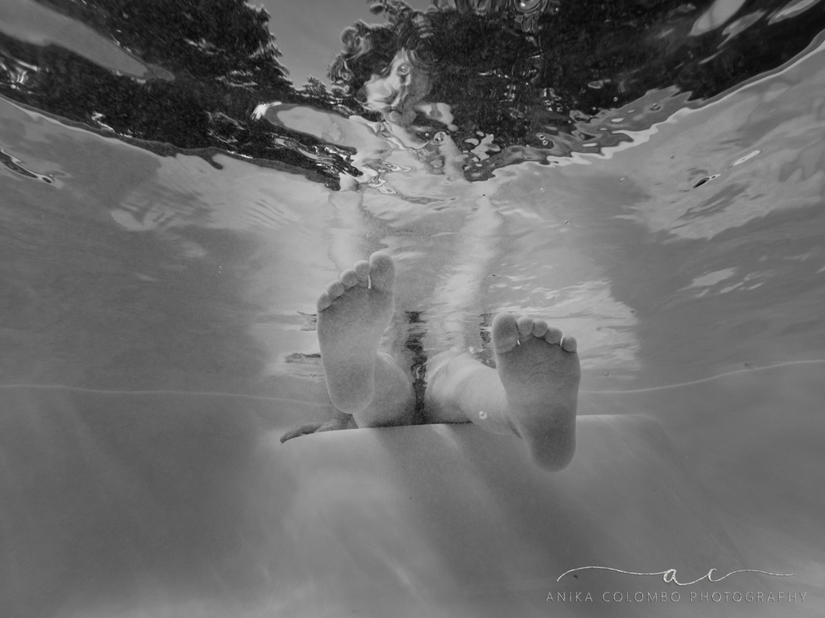 child's feet kicking in a pool