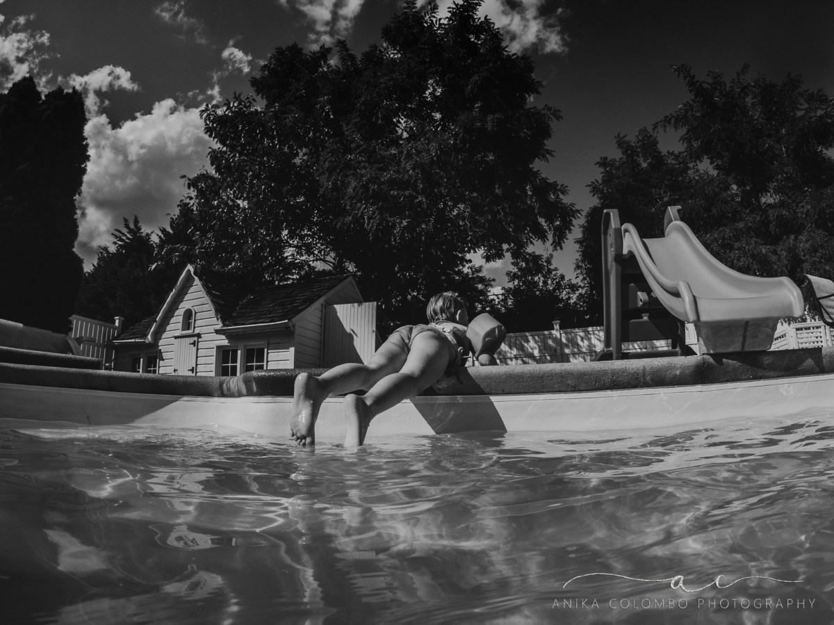 little girl laying on her tummy above a pool