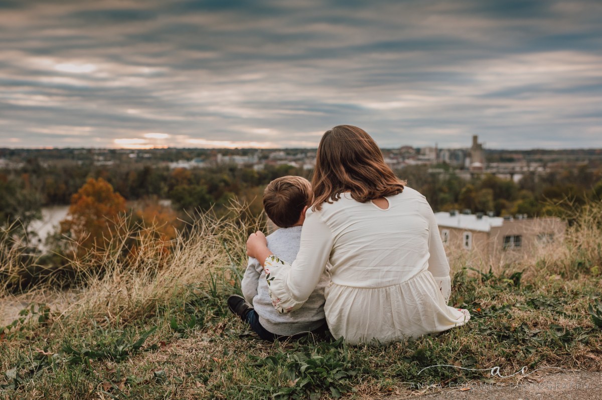 young girl with her arm around her younger brother sitting on a hilltop looking over the city of richmond in va