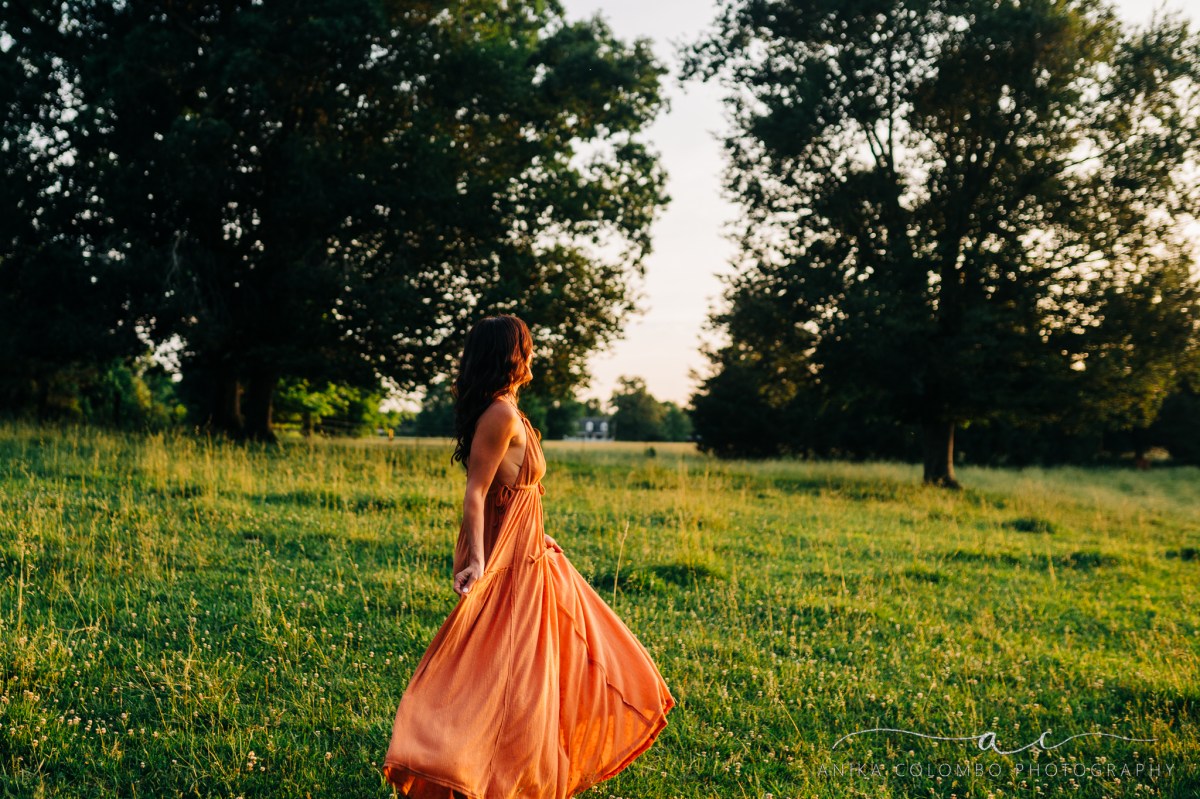 woman walking in a field at sunset
