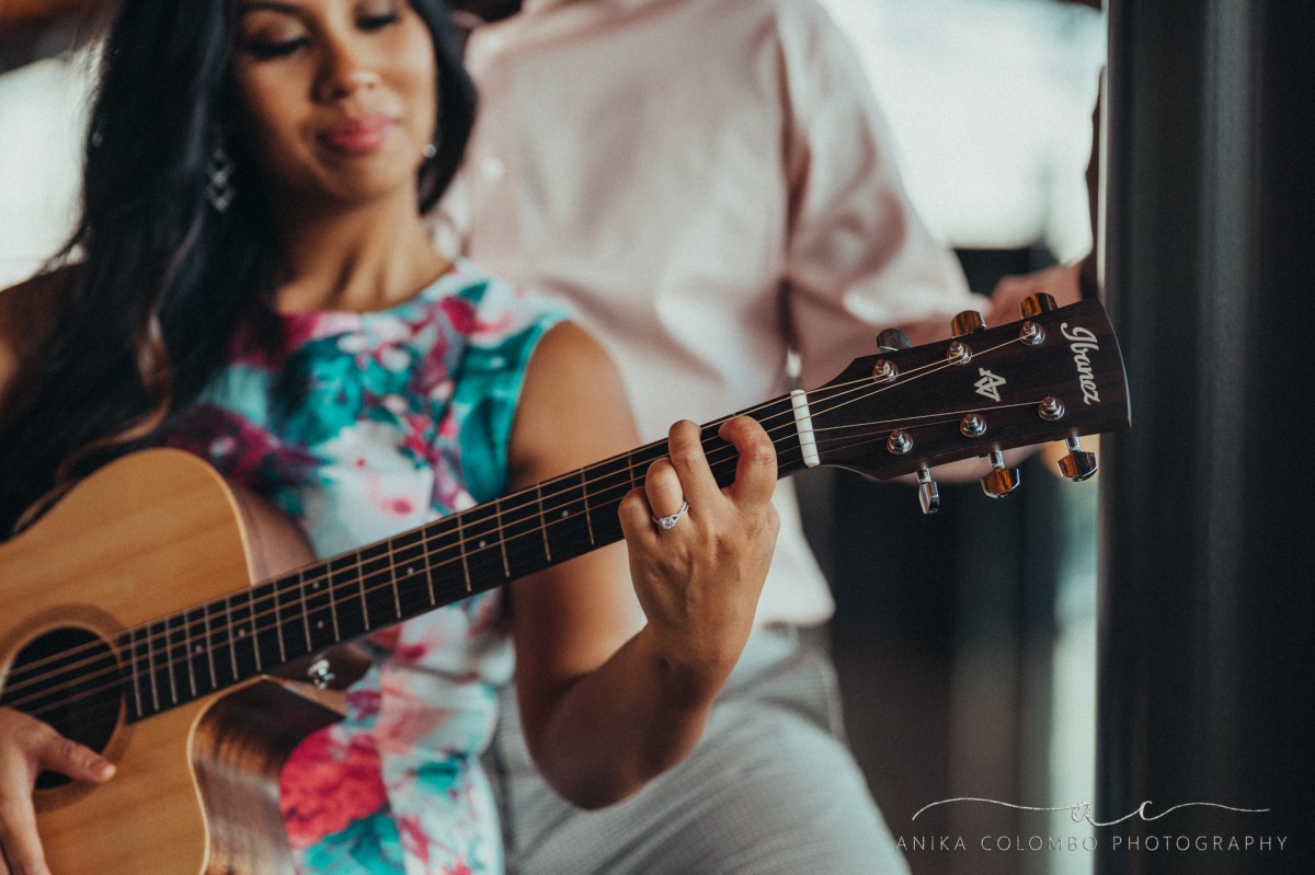 couple embracing as they play a guitar together